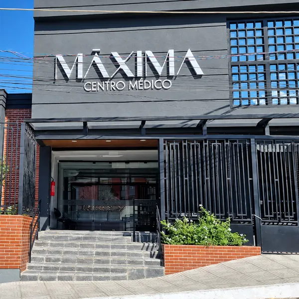 Fachada da Máxima Centro Médico com letreiro e entrada em vidro
