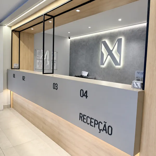 Símbolo da Máxima iluminado na parede da recepção